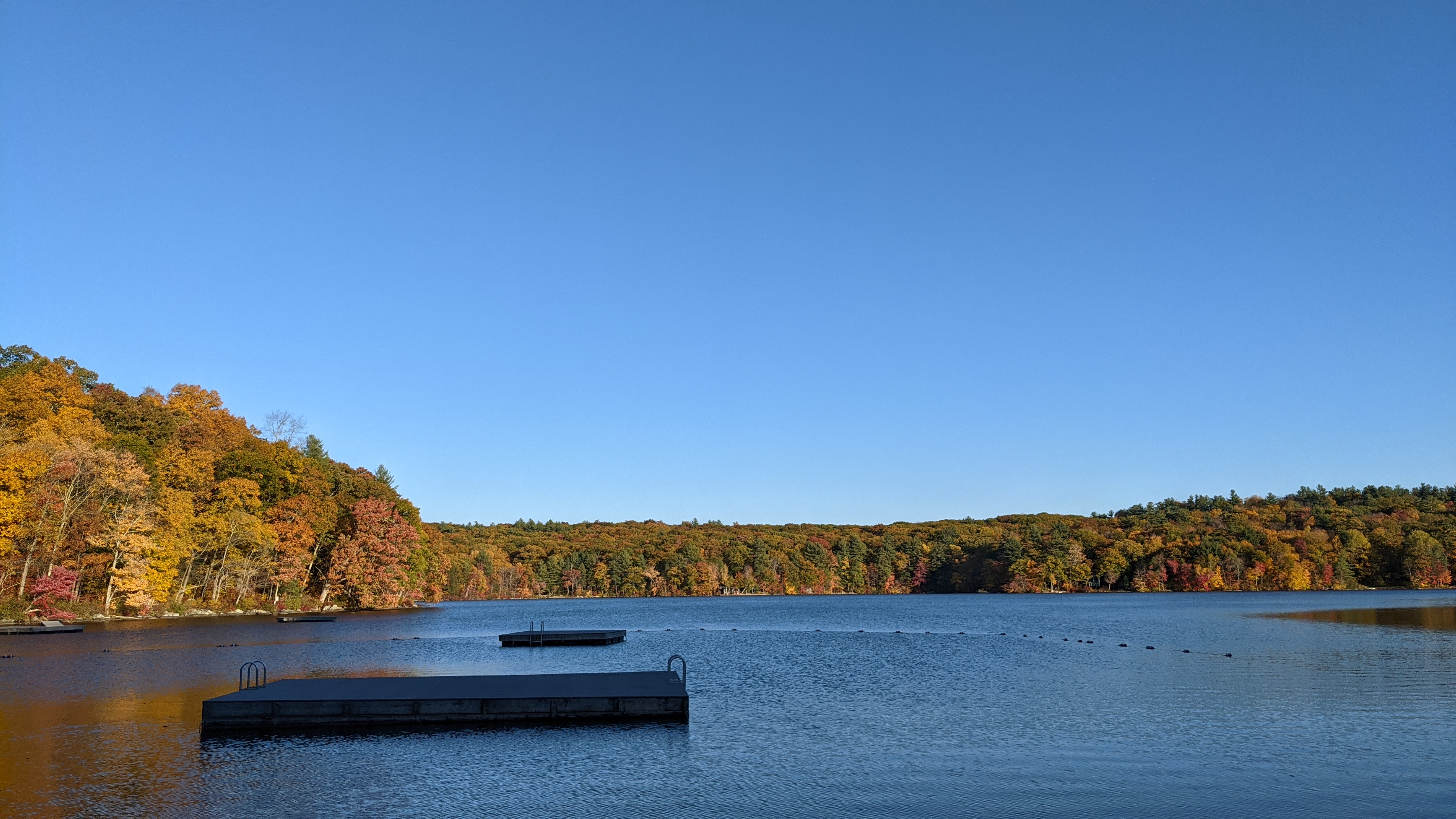 Cream Hill Lake in autumn, floating docks visible on the water